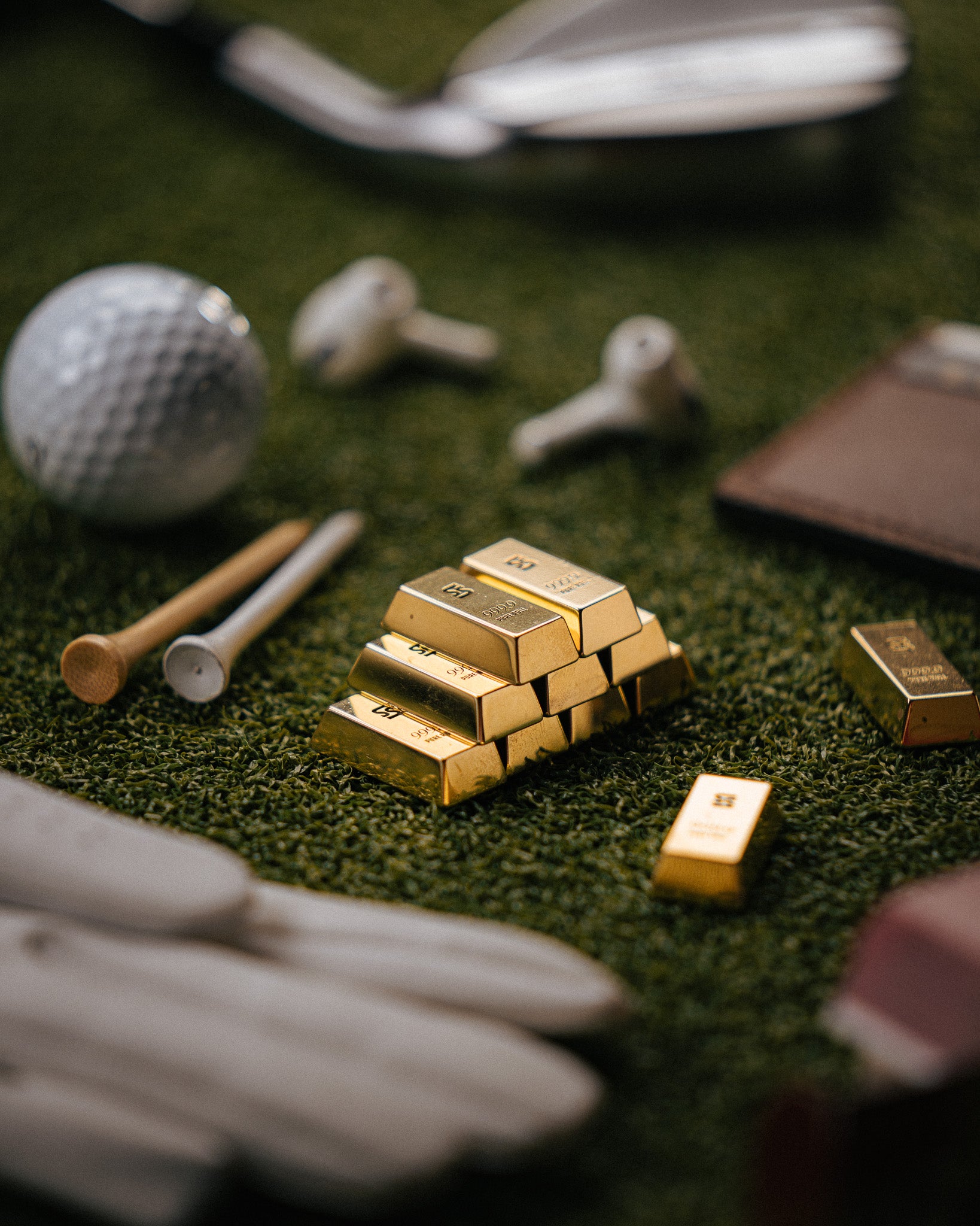 Stack of gold bar ball markers on grass